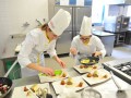 Mlade kuharice pazljivo pripravljajo krožnik