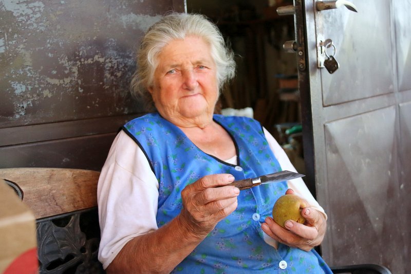 Alojzija Čeh s sklüčkom reže jabolka, foto: Ludvik Kramberger