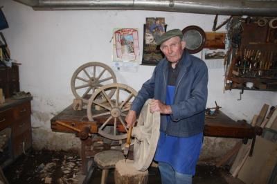 Alojz Čuš z lesenimi kolesi, ki jih je izdelal pred davnimi leti