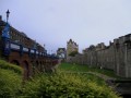 Obzidje Tower of London s pogledom proti mostu Tower Bridge